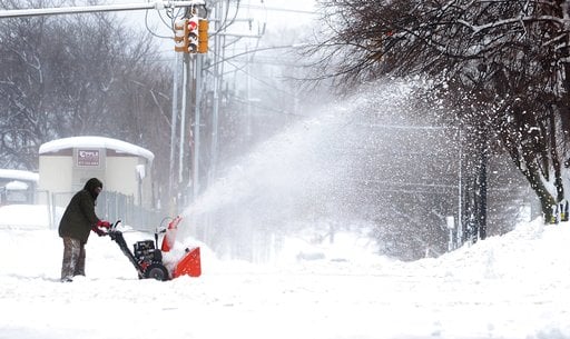 (Greg Wohlford/Erie Times-News via AP). A man clears snow on Tuesday, Dec. 26, 2017, in Erie, Pa. The National Weather Service office in Cleveland says Monday's storm brought 34 inches of snow, an all-time daily snowfall record for Erie. Another 19 inc...