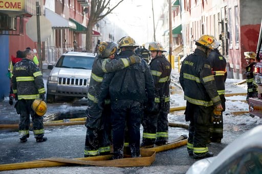 (Tim Tai/The Philadelphia Inquirer via AP). Firefighters embrace as their colleagues battle a row home fire in Philadelphia on Saturday, Jan. 6, 2018.  A veteran firefighter was fatally injured when a burning row home collapsed and he became pinned und...