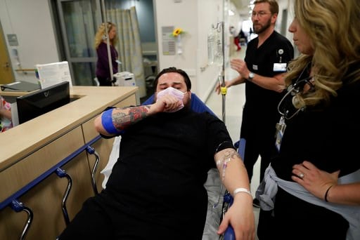 (AP Photo/Gregory Bull). In this Jan. 10, 2017 image, Donnie Cardenas recovers from the flu at the Palomar Medical Center in Escondido, Calif., on Wednesday, Jan. 10, 2018. The San Diego County resident said he was battling a heavy cough for days befor...
