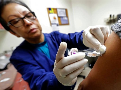 (AP Photo/Ted S. Warren). Ana Martinez, a medical assistant at the Sea Mar Community Health Center, gives a patient a flu shot, Thursday, Jan. 11, 2018 in Seattle. According to an update by the Centers for Disease Control and Prevention released Friday...
