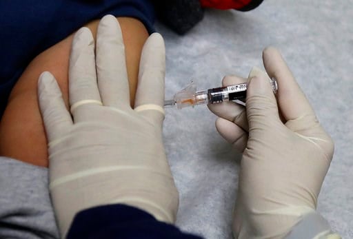 (AP Photo/Ted S. Warren). Ana Martinez, a medical assistant at the Sea Mar Community Health Center, gives a patient a flu shot, Thursday, Jan. 11, 2018 in Seattle. According to an update by the Centers for Disease Control and Prevention released Friday...