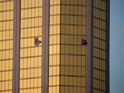 (AP Photo/John Locher, File). FILE - In this Monday, Oct. 2, 2017 file photo, drapes billow out of broken windows at the Mandalay Bay resort and casino on the Las Vegas Strip, following a mass shooting at a music festival in Las Vegas. A lawyer for Las...