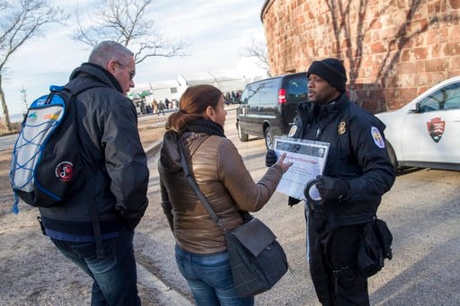 (AP Photo/Mary Altaffer). United States Park Police officer Fernandez, right, inform tourist that the Statue of Liberty is closed, Saturday, Jan. 20, 2018, in New York. The National Park Service announced that the Statue of Liberty and Ellis Island wou...