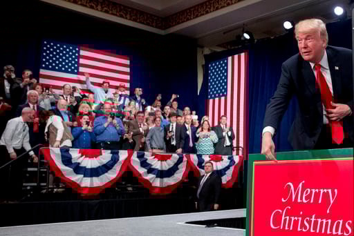 (AP Photo/Andrew Harnik, File). President Donald Trump points at a sign that reads "Merry Christmas" as he arrives at a tax reform rally at the St. Charles Convention Center, Wednesday, Nov. 29, 2017, in St. Charles, Mo.