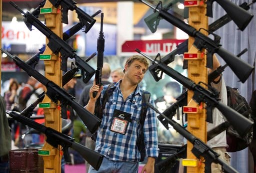 (AP Photo/Julie Jacobson, File). In this Jan. 17, 2013, file photo, Michael Kiefer, of DeFuniak Springs, Fla., checks out a display of rifles at the Rock River Arms booth during the 35th annual SHOT Show in Las Vegas.