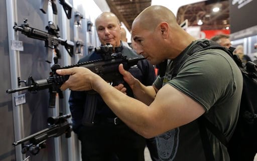 (AP Photo/Julie Jacobson, file). In this Jan. 14, 2014, file photo, John Montenegro of the Los Angeles Police Department S.W.A.T. team, examines a Sig Sauer MPX-K short barrel submachine gun during the Shooting Hunting and Outdoor Trade Show.