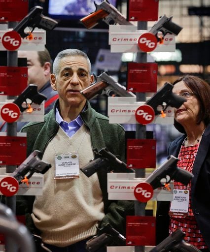 (AP Photo/Julie Jacobson, file). In this Jan. 14, 2014, file photo, knife manufacturers Les Halpern, left, and Marianne Halpern, of Three Rivers, Mass., examine a display of various handguns outfitted with laser sights.