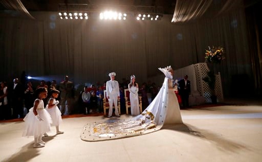 (AP Photo/Gerald Herbert). Krewe of Little Rascals Queen XXXV Miss Kristy Lynn Herkes walks past returning King XXIV Master Joshua Maurice and Queen XXIV Miss Cecelia Zimmermann at their Mardi Gras Ball in Kenner, La., Thursday, Jan. 25, 2018.